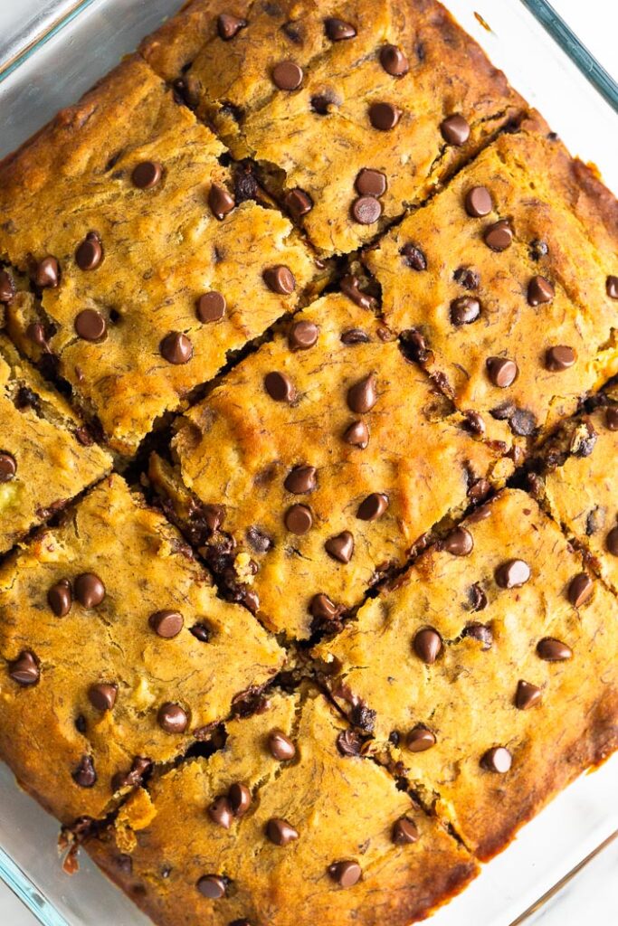Overhead shot of banana bread bars in a glass baking pan that are cut into 9 equal pieces.