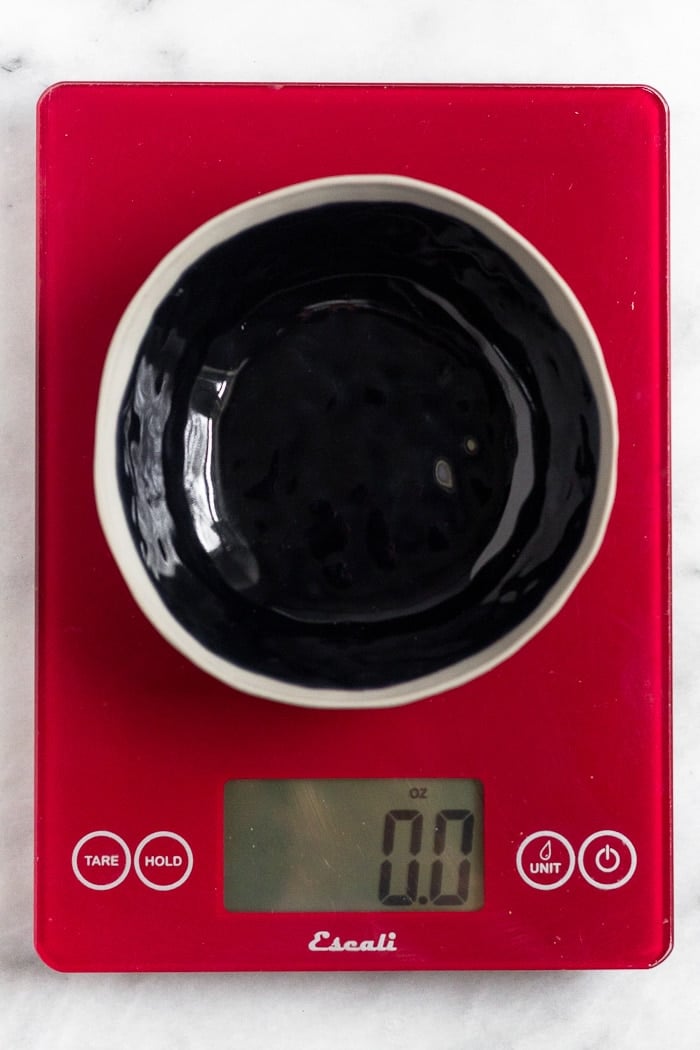 An empty bowl on a red food scale.