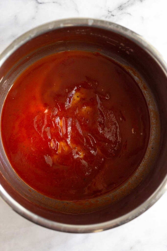 Large pot with barbecue sauce covering the bottom.