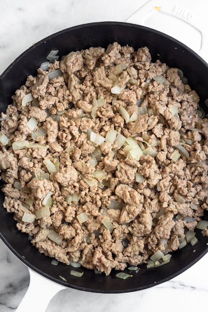 Large cast iron filled with sautéed ground turkey.