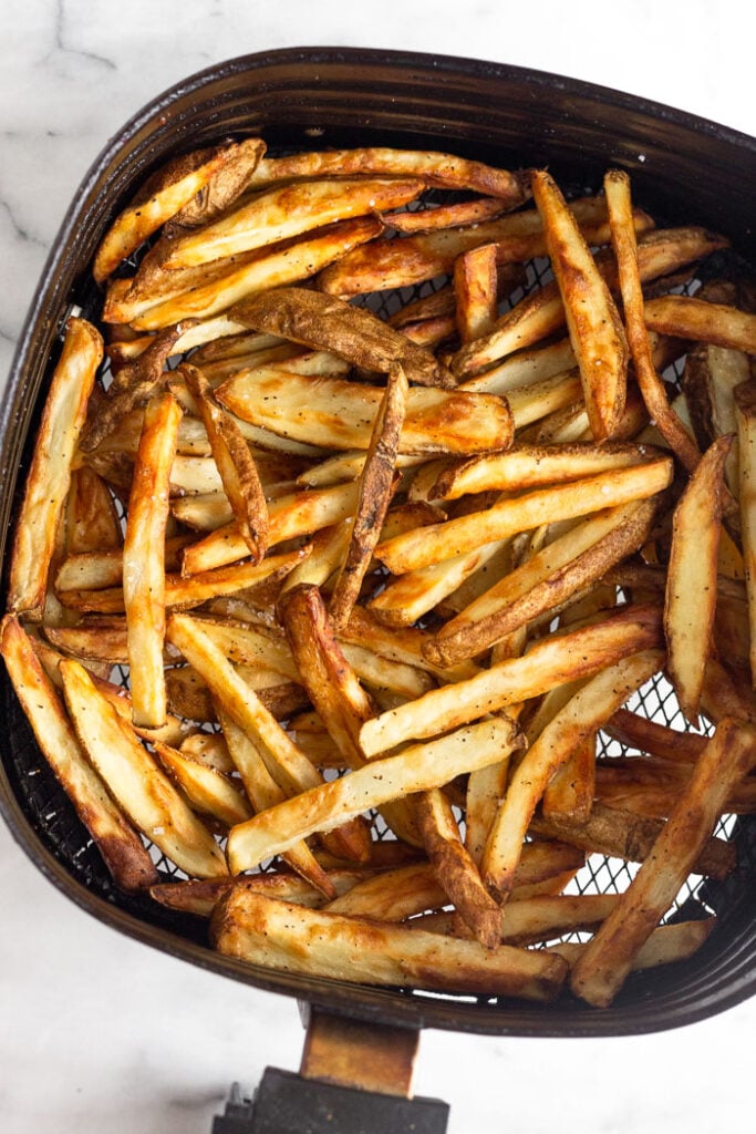 Homemade french fries in an air fryer basket.