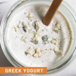 Jar of yogurt blue cheese dressing with a spatula in it.
