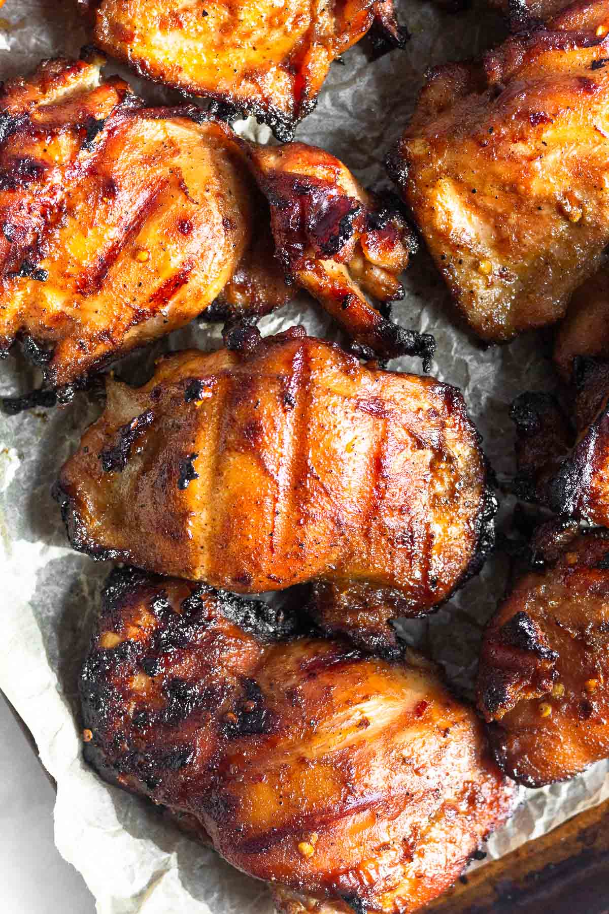 Overhead shot of grilled marinated chicken thighs on a baking sheet.
