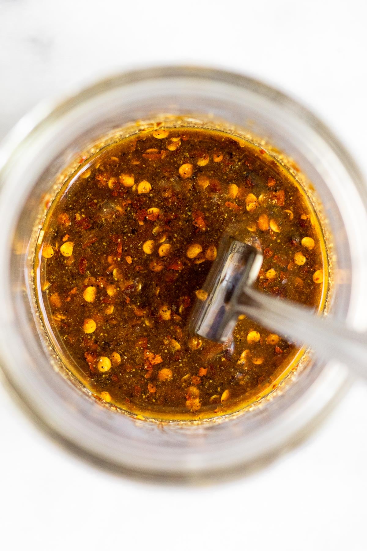 Glass jar filled with a Marinade for chicken thighs.