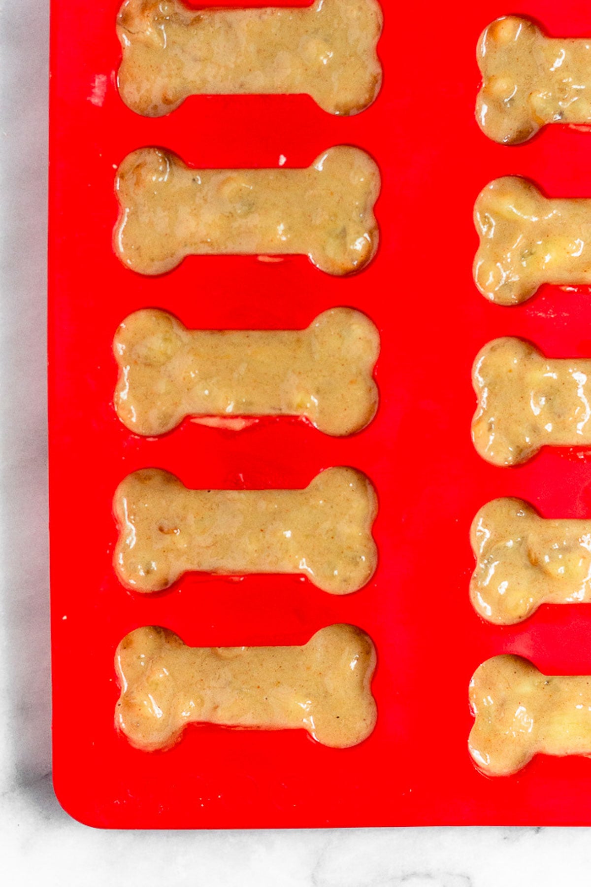 Dog bone silicone molds with peanut butter batter in them.