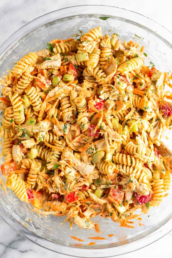 Overhead shot of buffalo chicken pasta salad in a large glass bowl.