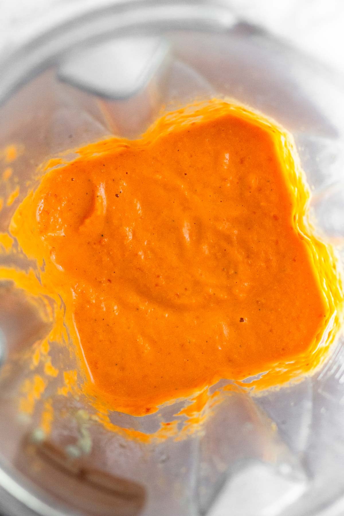 Blender filled with red pepper sauce.