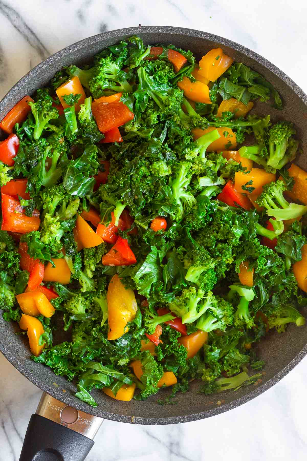 Saute pan filled with sautéed veggies.