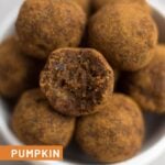 Side shot of a stacked bowl of Pumpkin Cinnamon Raisin Balls with a bite taken out of one.