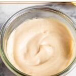 Homemade mayo in a jar with half a lemon and an egg next to it.