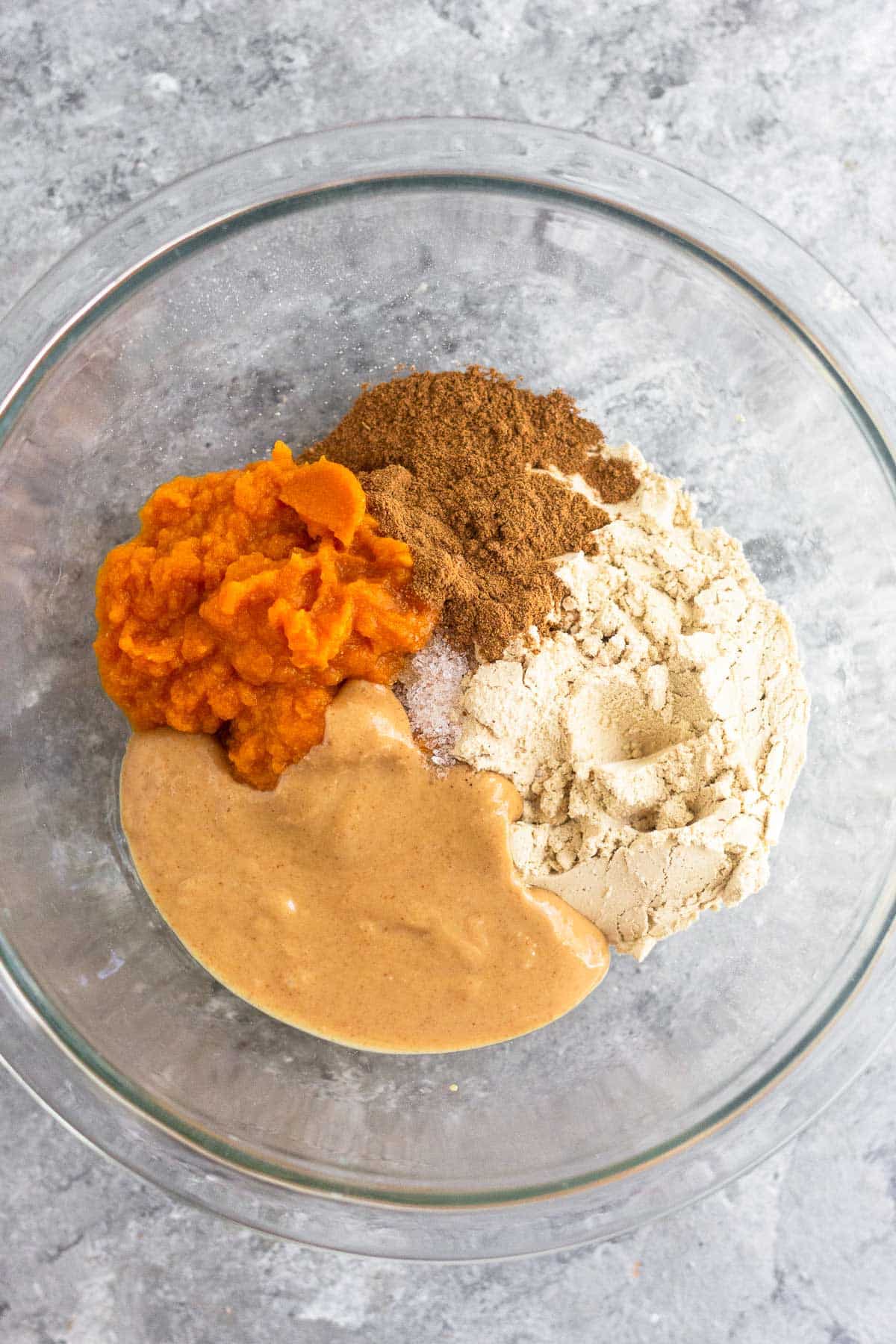 Bowl of pumpkin puree, spices, protein powder, and peanut butter.