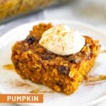 A piece of pumpkin baked oatmeal on a small white plate topped with greek yogurt, cinnamon, and honey. Behind it is a pan of more baked oatmeal.