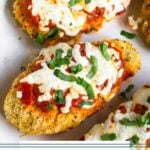 Plate of pieces of chicken parmesan made in the air fryer topped with fresh basil.