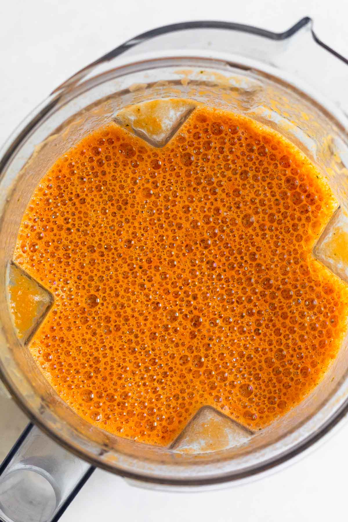 Blender filled with creamy tomato soup.