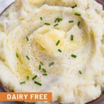Dairy free mashed potatoes in a bowl. They are topped with ghee, chives, and pepper.
