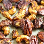 Close up of candied nuts on a large baking sheet.