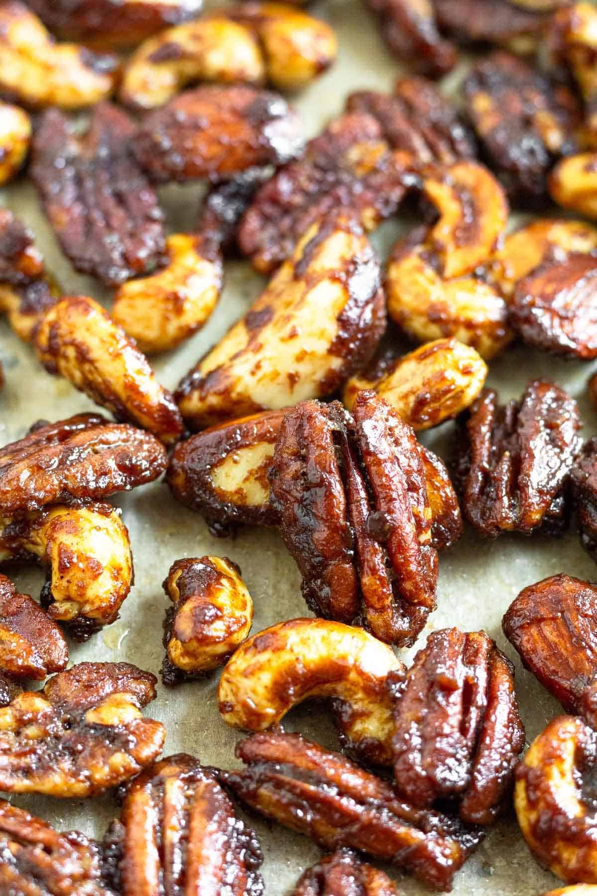 Close up of candied nuts on a large baking sheet.