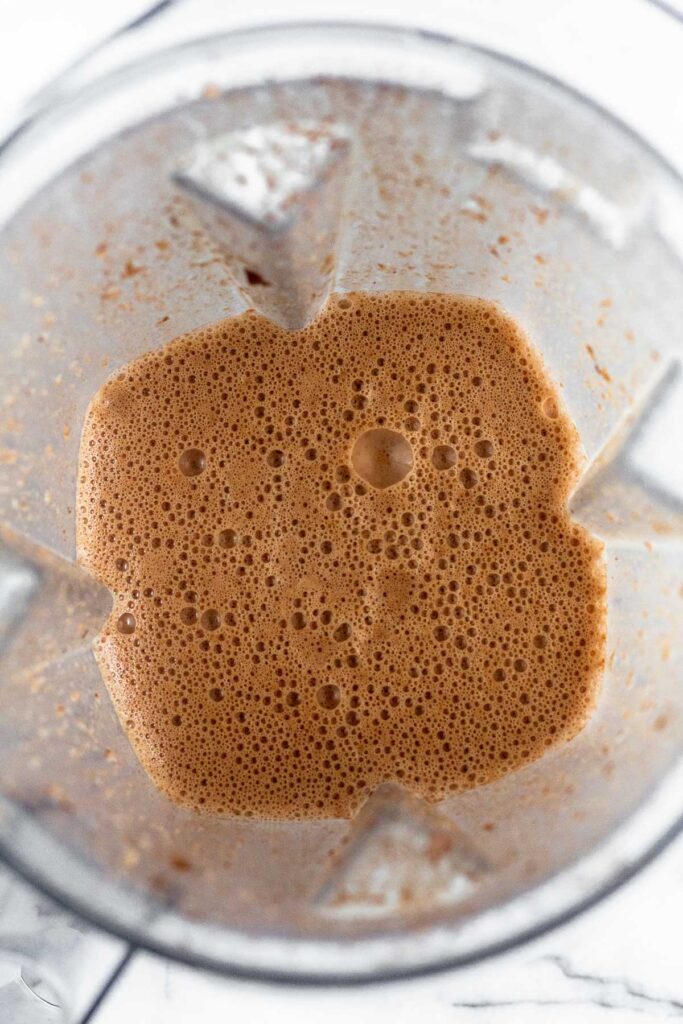 A frothy chocolate milk mixture in a blender.