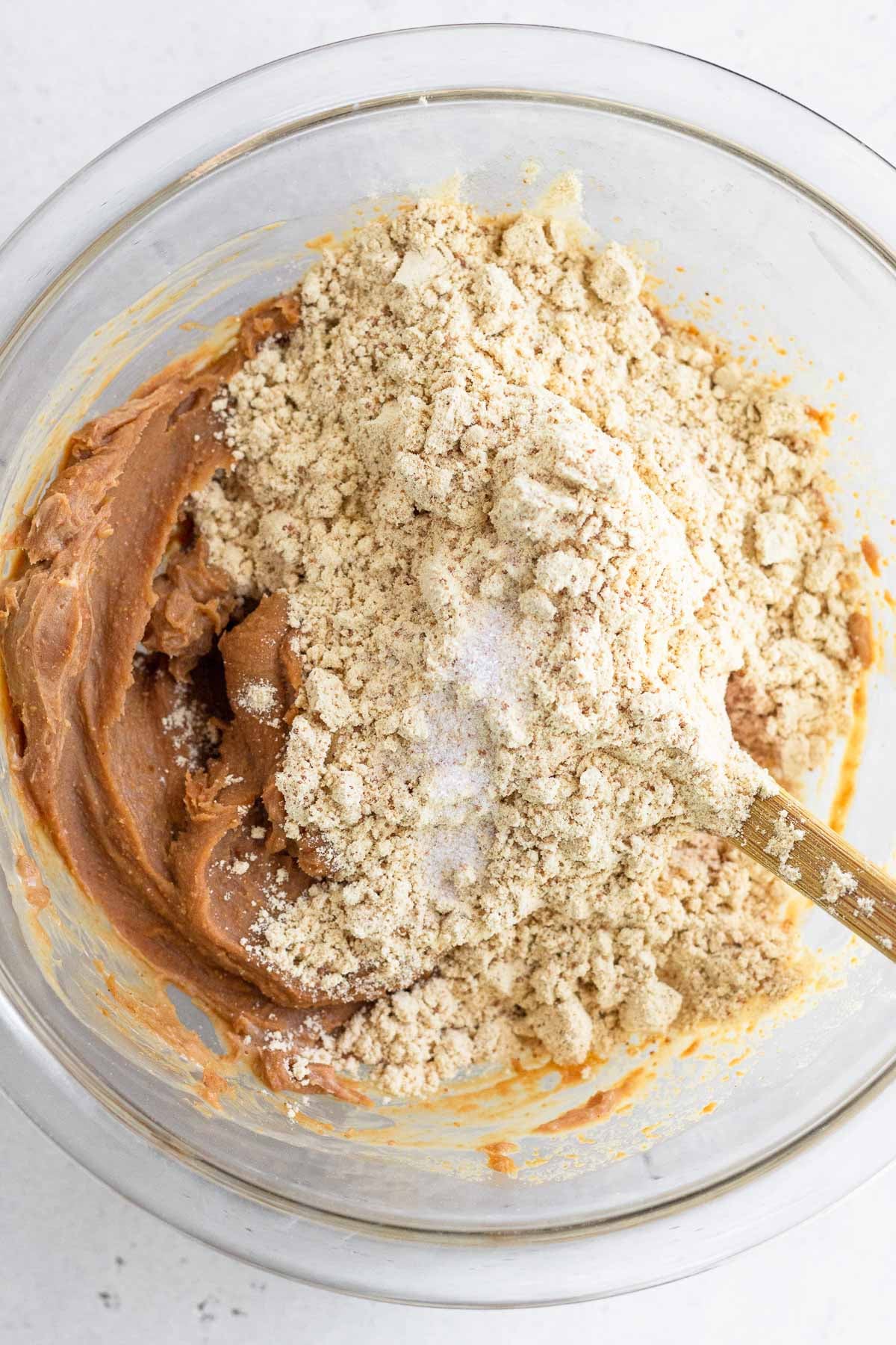 A mixture of cashew butter with protein powder and salt on top of it in a glass bowl.