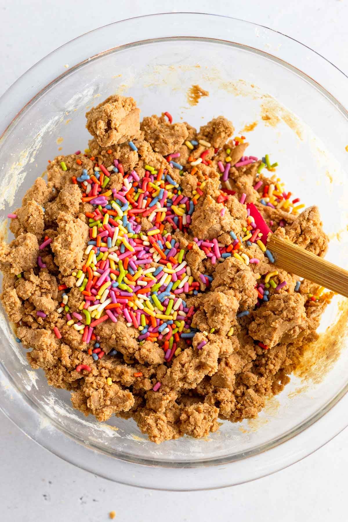 A bowl with the batter with sprinkles on top before it is mixed together.