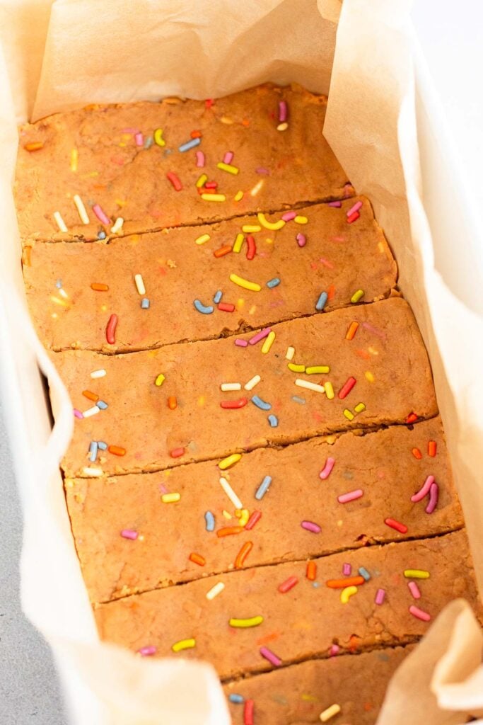 Six homemade birthday cake protein bars in the baking dish.