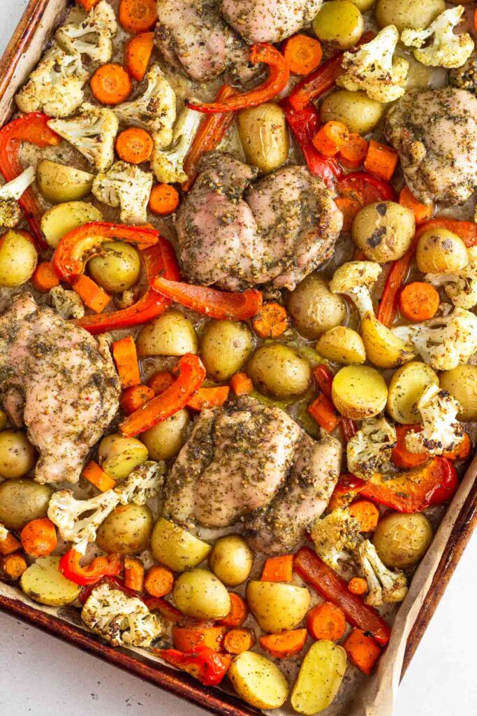 Sheet pan za'atar chicken with roasted potatoes, carrots, cauliflower, and red bell peppers.