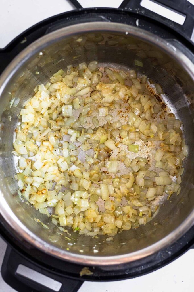 Pressure cooker with sautéed onions in it.