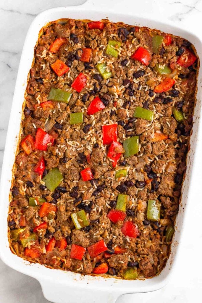 Casserole dish with a mixture of ground beef, peppers, black beans, and a salsa mixture after it has been baked.