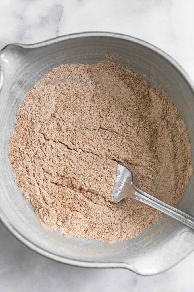 An overhead shot of a bowl with flour and spices mixed together. A fork is also in it.