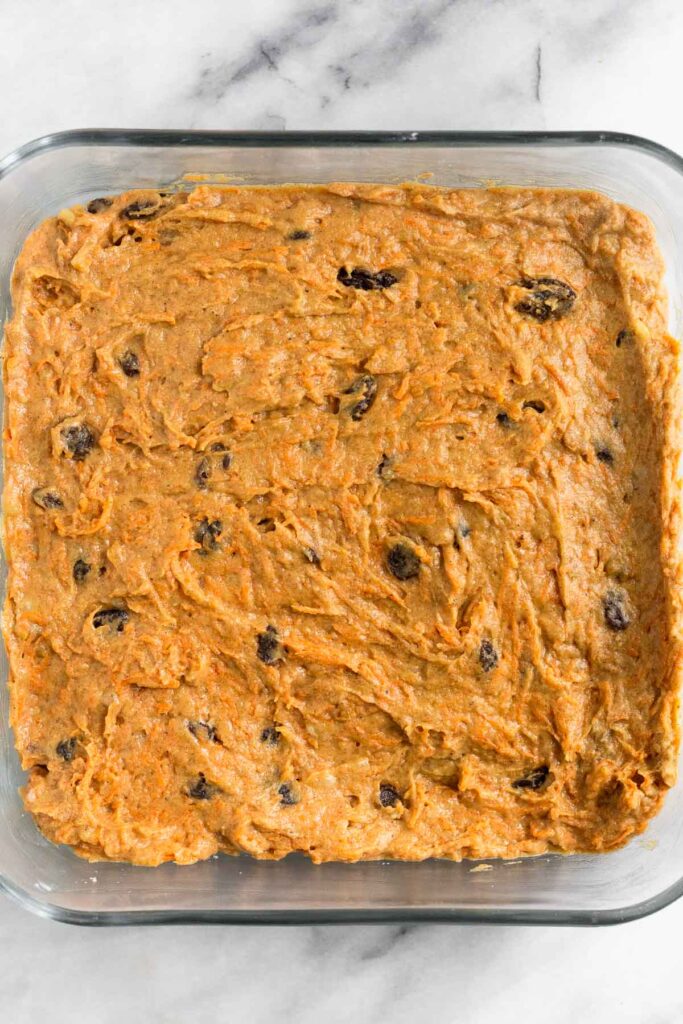 Carrot cake batter in a glass baking dish before it is baked.