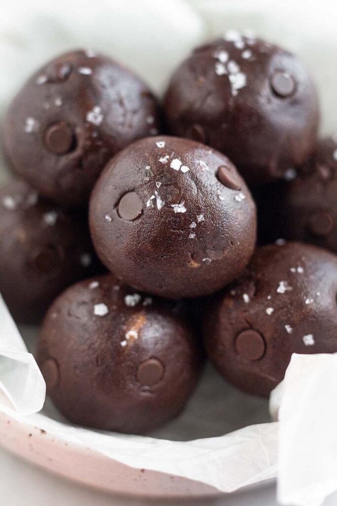 A bowl of healthy protein balls with chocolate chips in them. They are sprinkled with sea salt.