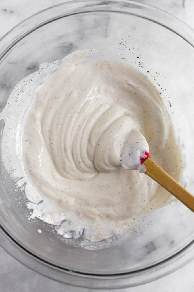 A large bowl with a greek yogurt mixture and a spatula in it.