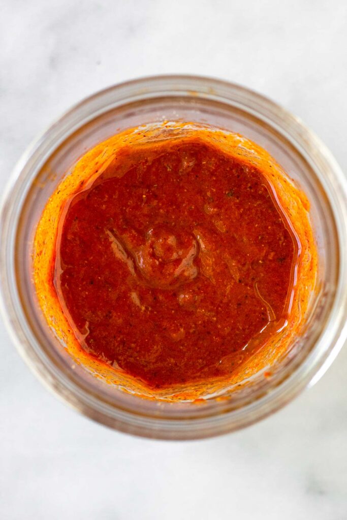 Glass jar filled with honey chipotle chicken marinade.