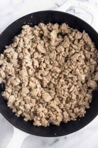 Cast iron skillet filled with sautéed ground turkey.