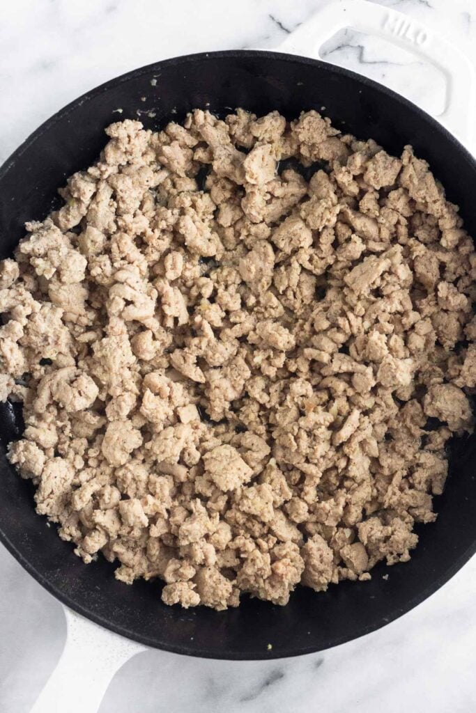 Cast iron skillet filled with sautéed ground turkey.