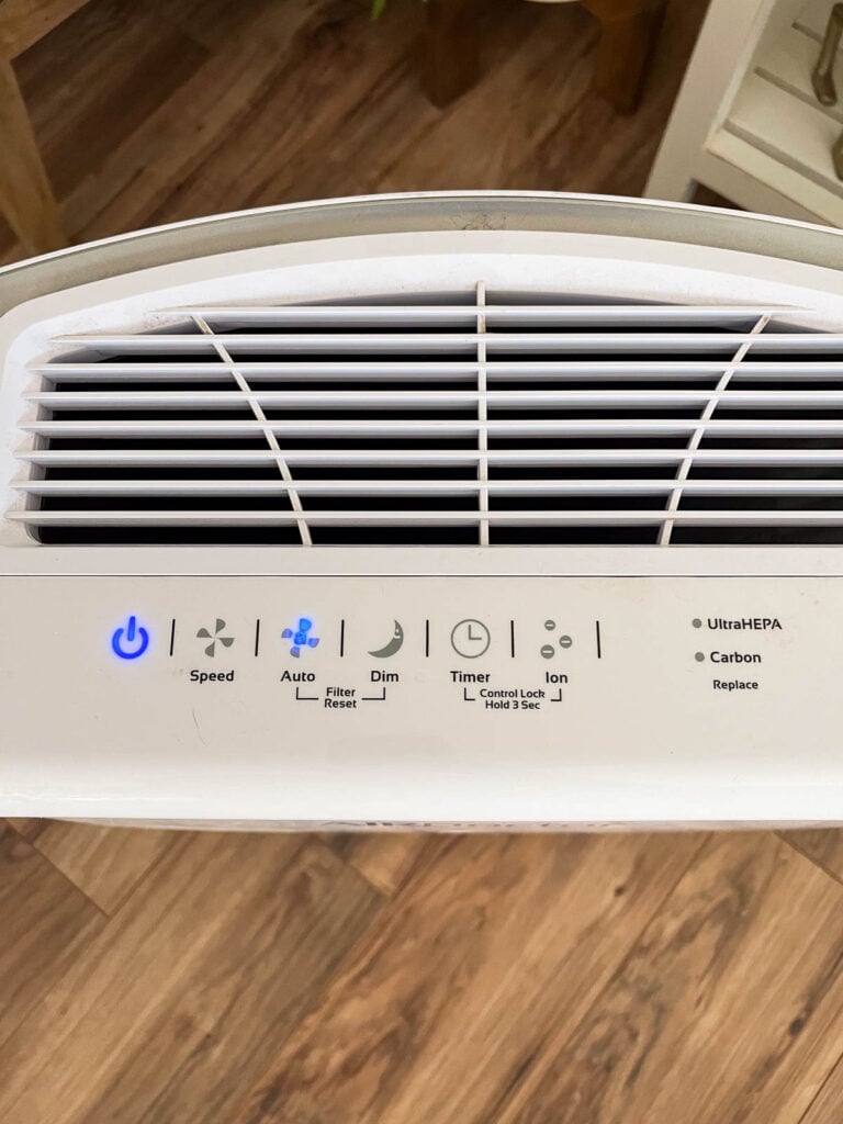 Overhead shot of the top of an air doctor with a power button, speed indicator, auto indicator, dim button, timer button, ion button, and a light indicator to let you know if the filters need replaced.