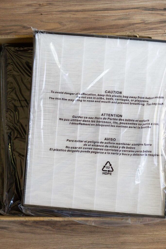 Replacement filters lying on the floor for an air purifier.