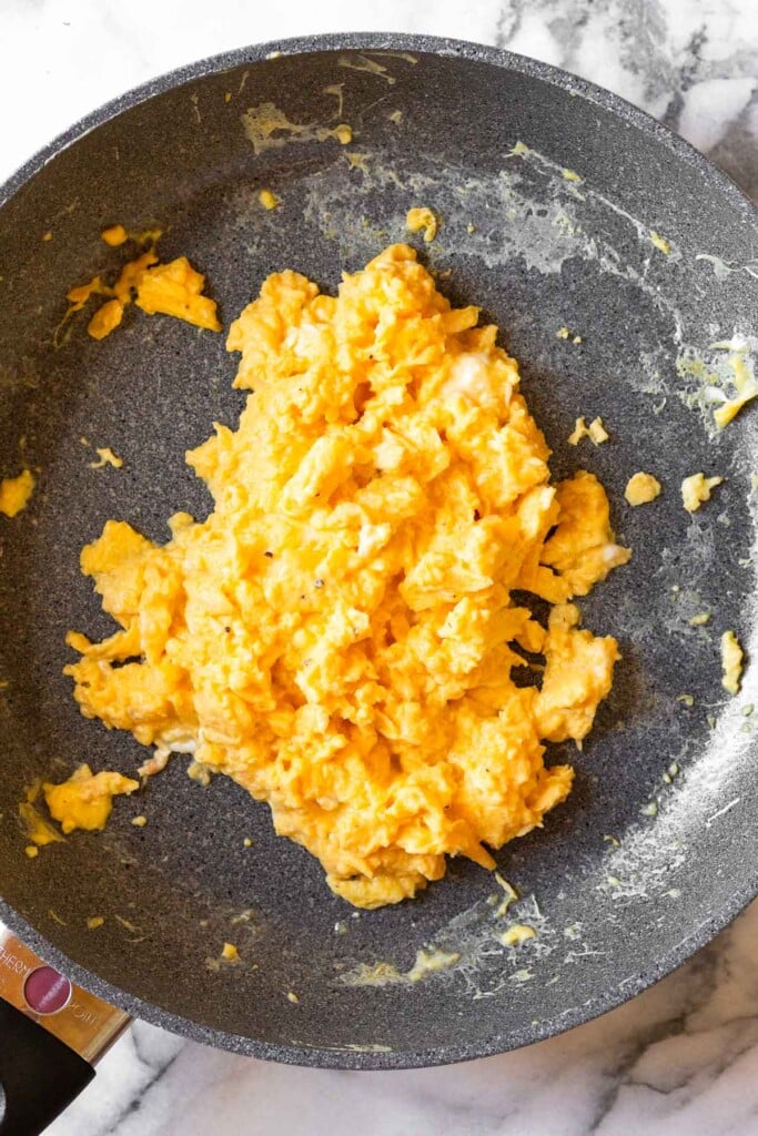 A plan filled with scrambled eggs with cottage cheese.