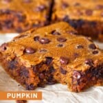 Close up a a pumpkin chocolate chip bar with a bite taken out of it. Behind it are more bars lined up.