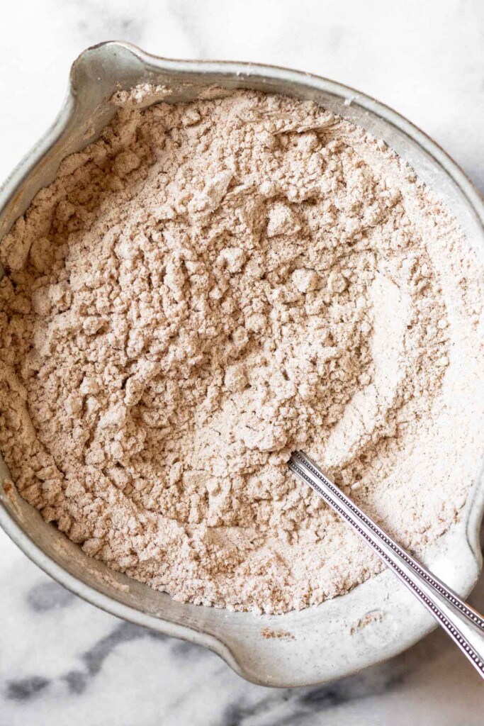 An overhead shot of a bowl with flour and spices mixed together. A fork is also in it.