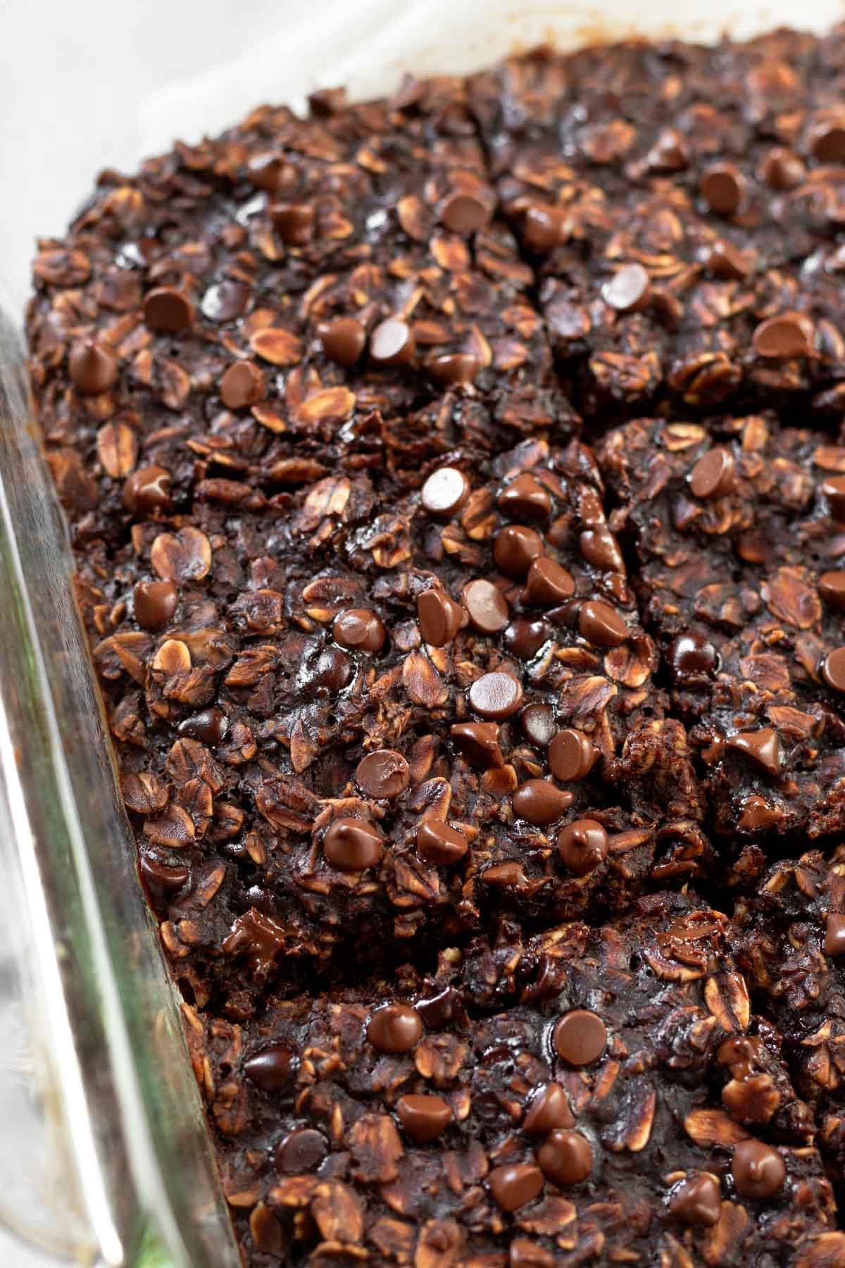 Close up of brownie baked oatmeal in a baking dish cut into squares.