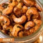 Close up overhead shot of honey roasted cashews in a glass jar.