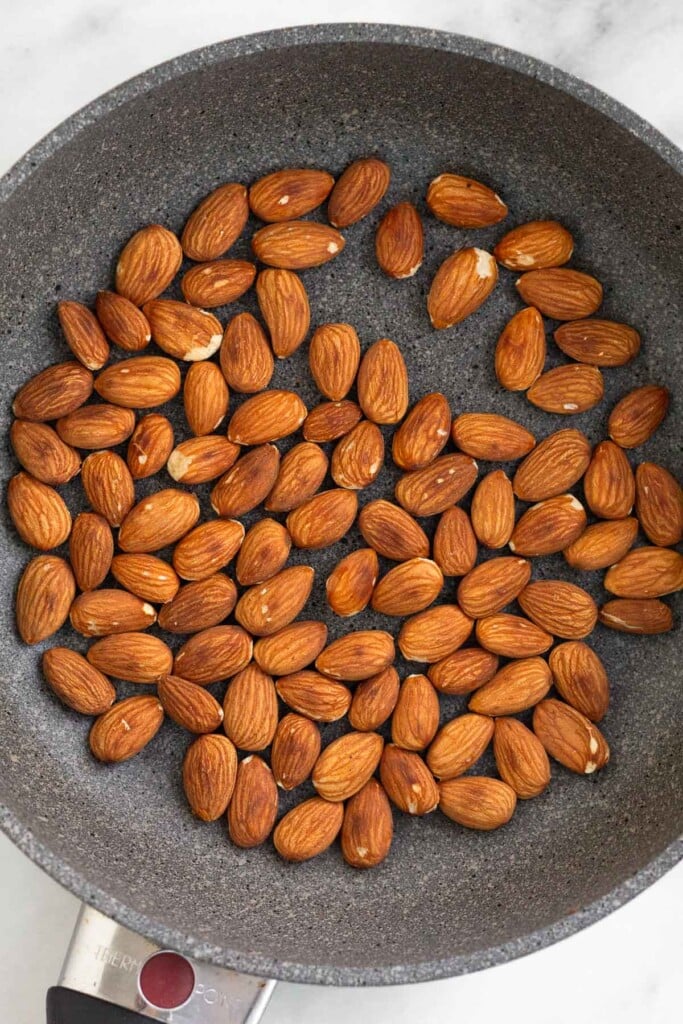 Small saute pan with toasted almonds in it.