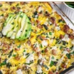 Ground turkey spaghetti squash casserole topped with ranch dressing, parsley, and sliced avocado. Off to the side of the dish is a bowl of more parsley.