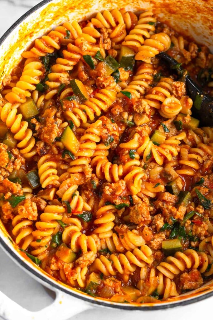 Close up of a pan filled with turkey pasta with veggies in a red sauce.