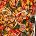Sheet pan sausage and veggies with peppers, onions, broccoli, and potatoes.