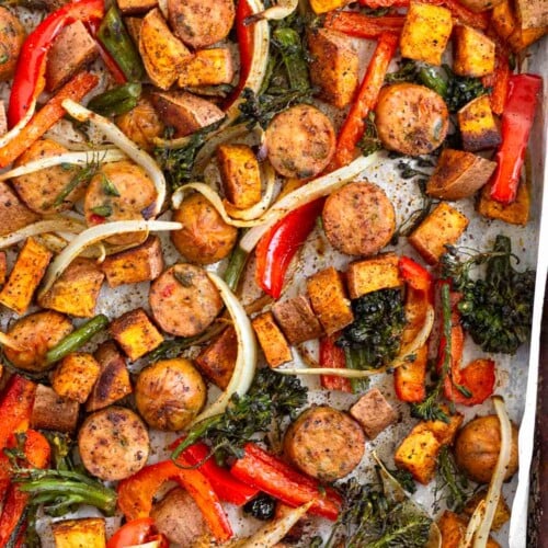 Sheet pan sausage and veggies with peppers, onions, broccoli, and potatoes.