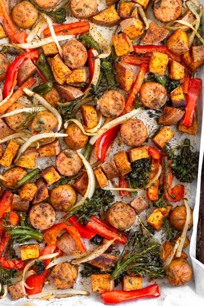 Sheet pan sausage and veggies with peppers, onions, broccoli, and potatoes.