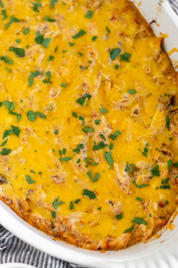 Chicken cheese dip topped with cilantro in a white baking dish.