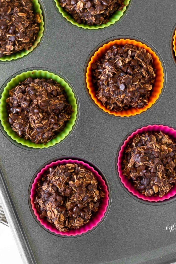 Healthy chocolate oatmeal muffins in silicone liners in a muffin tin.